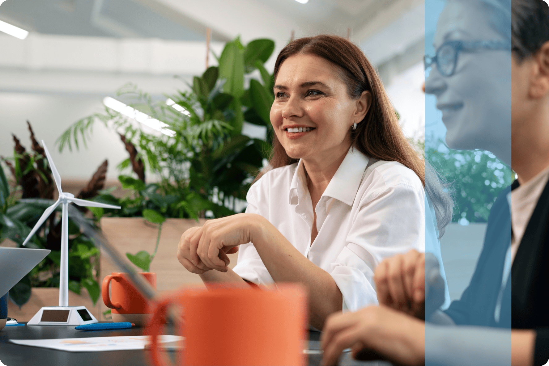 A professional woman smiling during a business strategy meeting, representing the Projects and Tendering recruitment team.