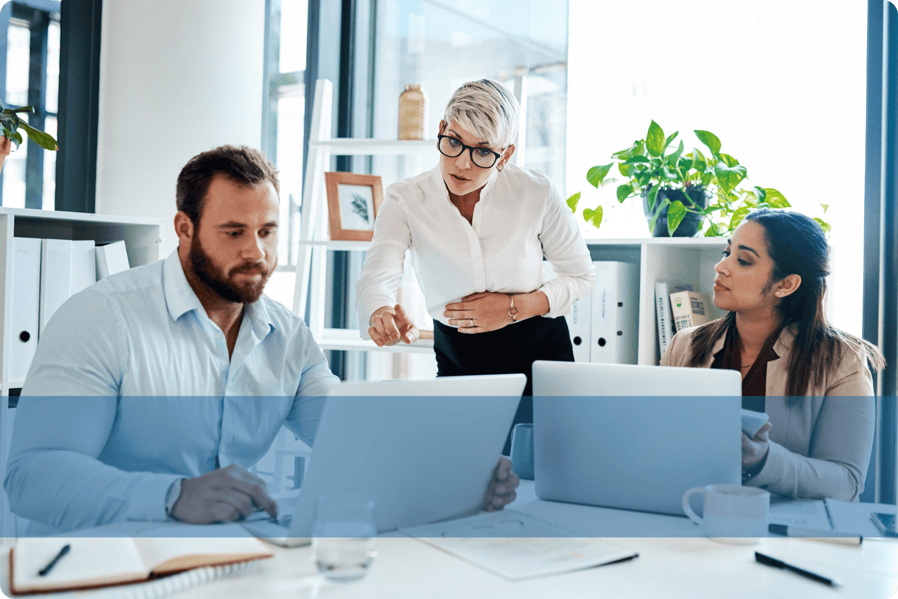 Professionals engaging in a discussion at a desk, representing the Konnekt IT recruitment team analysing technical candidate pipelines.
